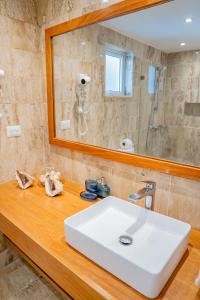 ein Badezimmer mit einem weißen Waschbecken und einem Spiegel in der Unterkunft Xeliter Green One Playa Dorada in San Felipe de Puerto Plata