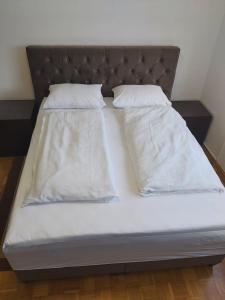a bed with two white pillows on it at Apartman Zenica in Zenica