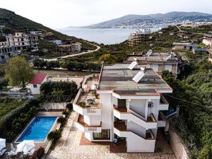 een huis op een heuvel met een zwembad bij Villa La Quiete - Adults only in Sarandë