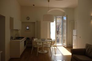 una cucina e un soggiorno con tavolo e sedie di Via Gattini Suite a Matera