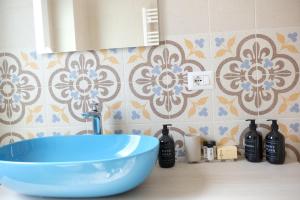 un lavandino blu in bagno con parete piastrellata di Via Gattini Suite a Matera