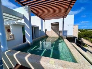 a swimming pool on the side of a house at Spacious Penthouse w/ Private Pool & Maid Service in Puerto Morelos