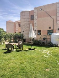 an umbrella sitting in the grass in front of a building at العين السخنة in Ain Sokhna