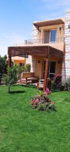 a house with a yard with green grass and flowers at العين السخنة in Ain Sokhna