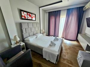 a bedroom with a bed and two chairs at Hotel Pini in Sarandë