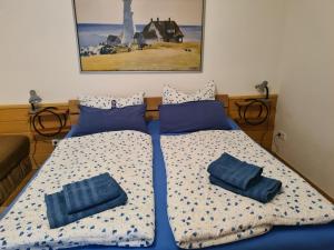 a bedroom with two beds with blue pillows on them at Haus Waldesruh in Lubmin