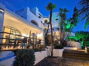 a villa with a table and palm trees at night at Paco Residence Benessere & Relax in Ischia