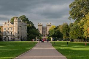 Leute gehen einen Weg vor einem Schloss entlang in der Unterkunft Charles House - Windsor Castle in Windsor