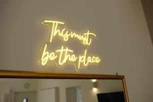 Un'insegna al neon che dice che pensa sia il ritmo di Via Gattini Suite a Matera