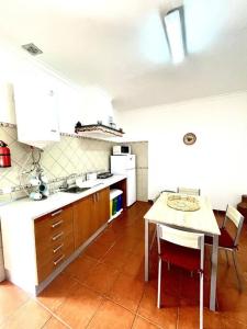 a kitchen with a table and a counter top at A Casa D'Avó Chica - Alentejo in Portel
