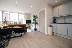 a kitchen and living room with a couch and a table at Casablanca 4 - Cardiff Bay - 2 Bed Apartment in Cardiff