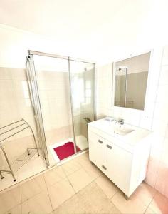 a bathroom with a shower and a sink and a mirror at A Casa D'Avó Chica - Alentejo in Portel