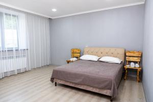 a bedroom with a bed and a large window at Loly Luxury Guest House in Dilijan