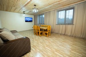 a living room with a couch and a table and chairs at Loly Luxury Guest House in Dilijan