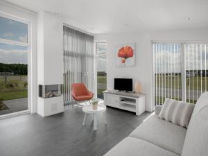 sala de estar blanca con sofá y TV en Water Resort Oosterschelde 2, en Wemeldinge
