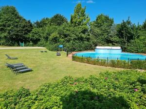 a large swimming pool in a grassy yard at Nice apartment in Olburgen in Olburgen