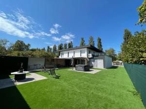 een huis met een grote tuin met groen gras bij Szil-Luxury Apartman in Zamárdi