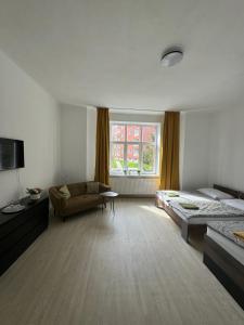 a large room with a bed and a couch at Pension Moravia in Olomouc
