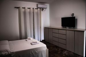 Cette chambre comprend un lit et une télévision sur une commode. dans l'établissement Villa La Quiete - Adults only, à Saranda