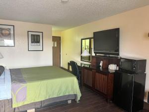德明Motel 6 Deming, NM的一间配有床和平板电视的酒店房间