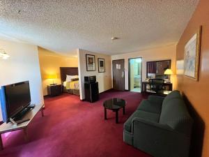 a living room with a couch and a tv and a bed at Motel 6 Deming, NM in Deming