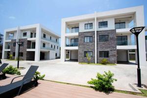 ein Apartmenthaus mit einer Bank davor in der Unterkunft Stay Play Away Residences - Luxury 4 bed, Airport Residential, Accra in Accra