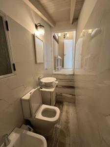 a white bathroom with a toilet and a sink at Apart del Centro in Esquina