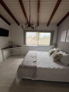 a bedroom with a large bed and a chandelier at Apart del Centro in Esquina +2 photos