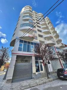 ein hohes weißes Apartmenthaus in einer Stadtstraße in der Unterkunft Alba Marina in Vlorë