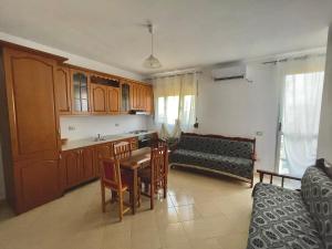 eine Küche und ein Wohnzimmer mit einem Sofa und einem Tisch in der Unterkunft Alba Marina in Vlorë