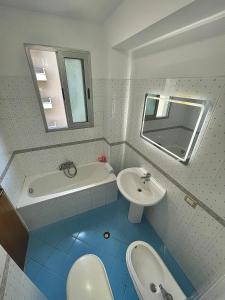 ein Badezimmer mit einem Waschbecken, einer Badewanne und einem WC in der Unterkunft Alba Marina in Vlorë