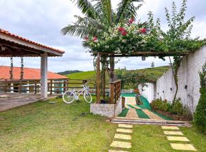 een tuin met een pergola met een fiets in de tuin bij Chácara com lazer completo e piscina em Igaratá - SP in Igaratá