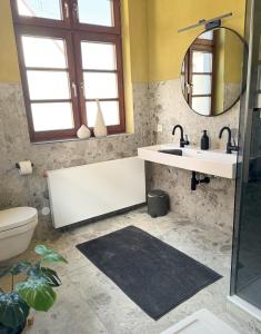 a bathroom with a tub and a sink and a mirror at Ferienwohnung Ava - Heiligkreuztal in Heiligkreuztal