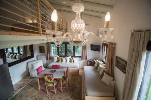 ein Wohnzimmer mit einem Sofa und einem Kronleuchter in der Unterkunft Country House Spitaki Γραφείο in Velika