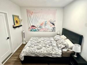a bedroom with a bed and a painting on the wall at Beautiful Luxury Shared Home in Montreal in Montreal