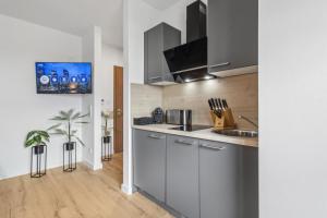 a kitchen with white cabinets and a sink at SUITE4ME - Moderne Apartments I Küche I Balkon I Waschmaschine in Dietzenbach +20 photos