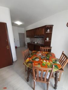 een eettafel met stoelen en een keuken bij Casa Greta in Iglesias