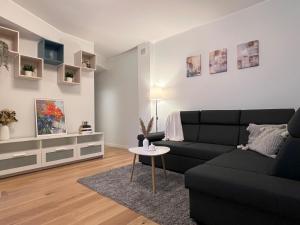 a living room with a black couch and a table at Spacious Apartment in Kadriorg, Tallinn City Centre in Tallinn