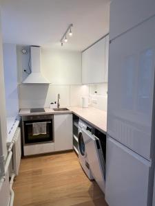 cocina blanca con fregadero y lavavajillas en Spacious Apartment in Kadriorg, Tallinn City Centre en Tallin