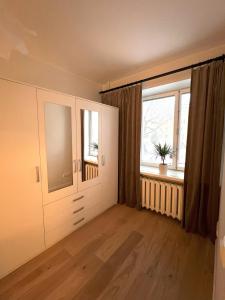 una sala de estar vacía con ventana y suelo de madera en Spacious Apartment in Kadriorg, Tallinn City Centre en Tallin