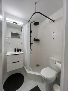 y baño blanco con aseo y ducha. en Spacious Apartment in Kadriorg, Tallinn City Centre en Tallin