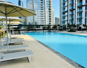 a swimming pool with two lounge chairs and an umbrella at Burj Crown - First Class Boulevard View, 9 min Walk Dubai Mall in Dubai +34 photos