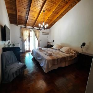 a bedroom with a large bed and a wooden ceiling at HERMOSA CASA en CHACRAS DE CORIA in Chacras de Coria