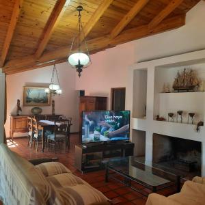un soggiorno con TV e una sala da pranzo di HERMOSA CASA en CHACRAS DE CORIA a Chacras de Coria