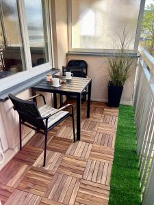 a patio with a table and chairs on a balcony at Poppy Elegance City Center & Free parking in Sarajevo