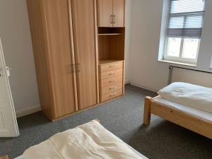 ein Schlafzimmer mit einem Bett, einer Kommode und einem Schrank in der Unterkunft Drei Linden Jasper in Wolfenbüttel