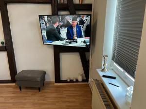 einen Flachbild-TV an einer Wand in einem Zimmer in der Unterkunft Drei Linden Jasper in Wolfenbüttel