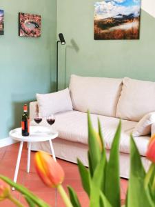 a living room with a couch and two glasses of wine at CASA ARYA - Independent House - Near the Walls in Lucca +28 photos