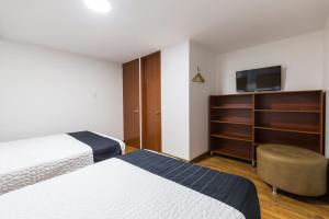 um quarto de hotel com duas camas e uma televisão em Hotel Casa Botero 202 em Bogotá