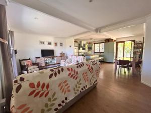 a living room with a bed and a dining room at Camelot in Yamba